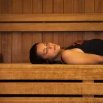 Jeune femme relaxée profitant d'une séance de sauna en bois traditionnel dans un centre de bien-être