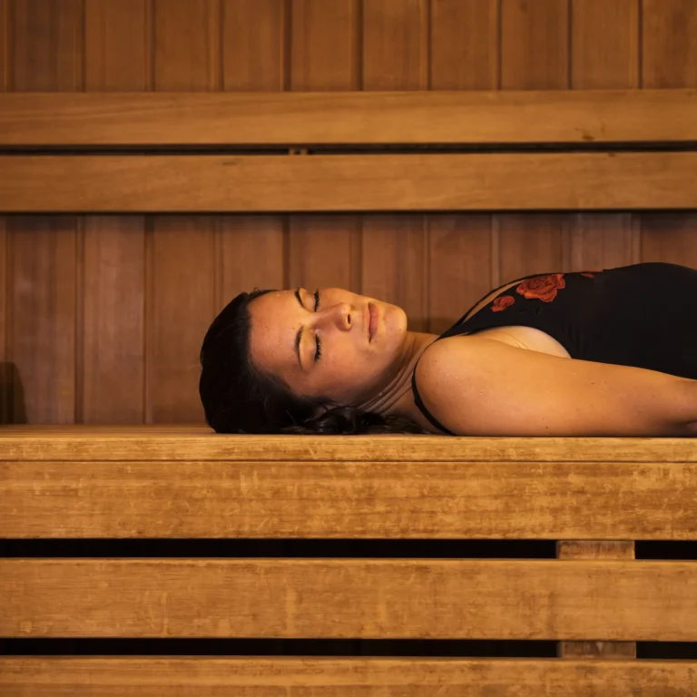 Jeune femme relaxée profitant d'une séance de sauna en bois traditionnel dans un centre de bien-être